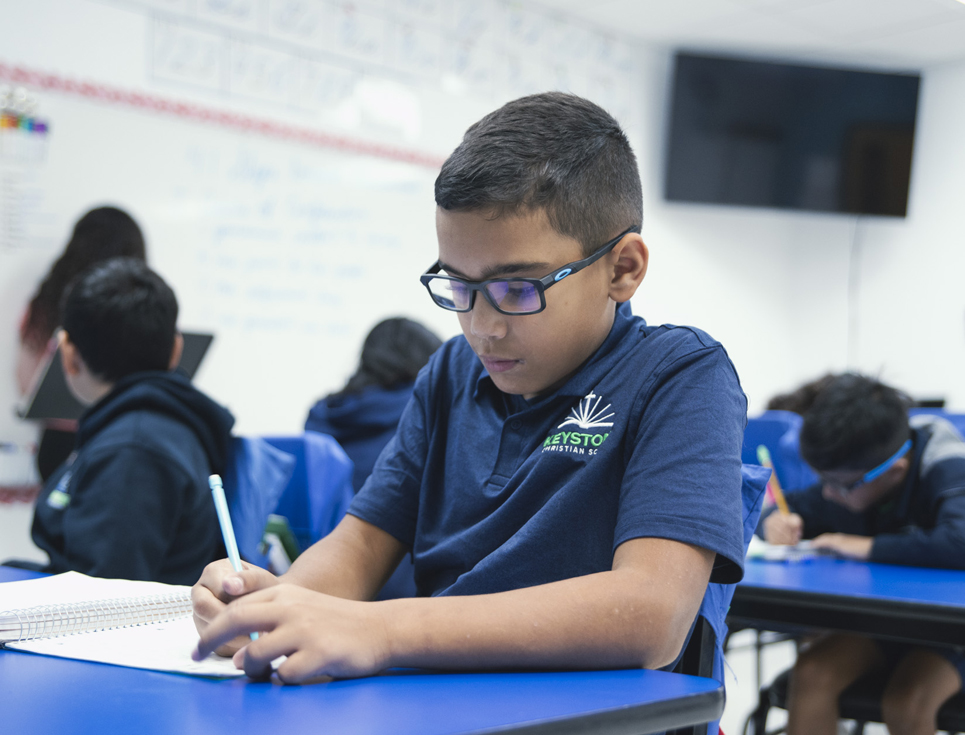 Handsome young student taking notes in class.